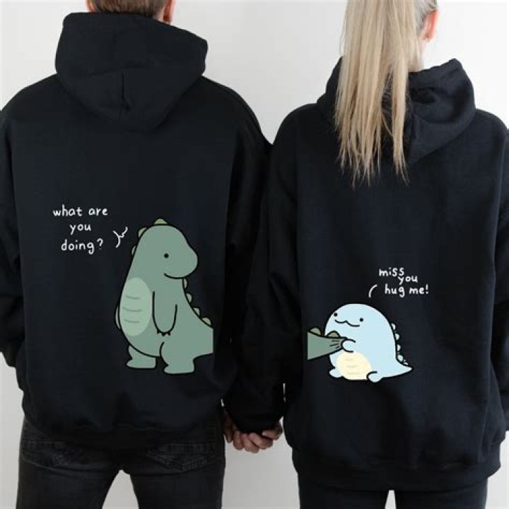 A couple wearing fluffy hoodies in the kitchen